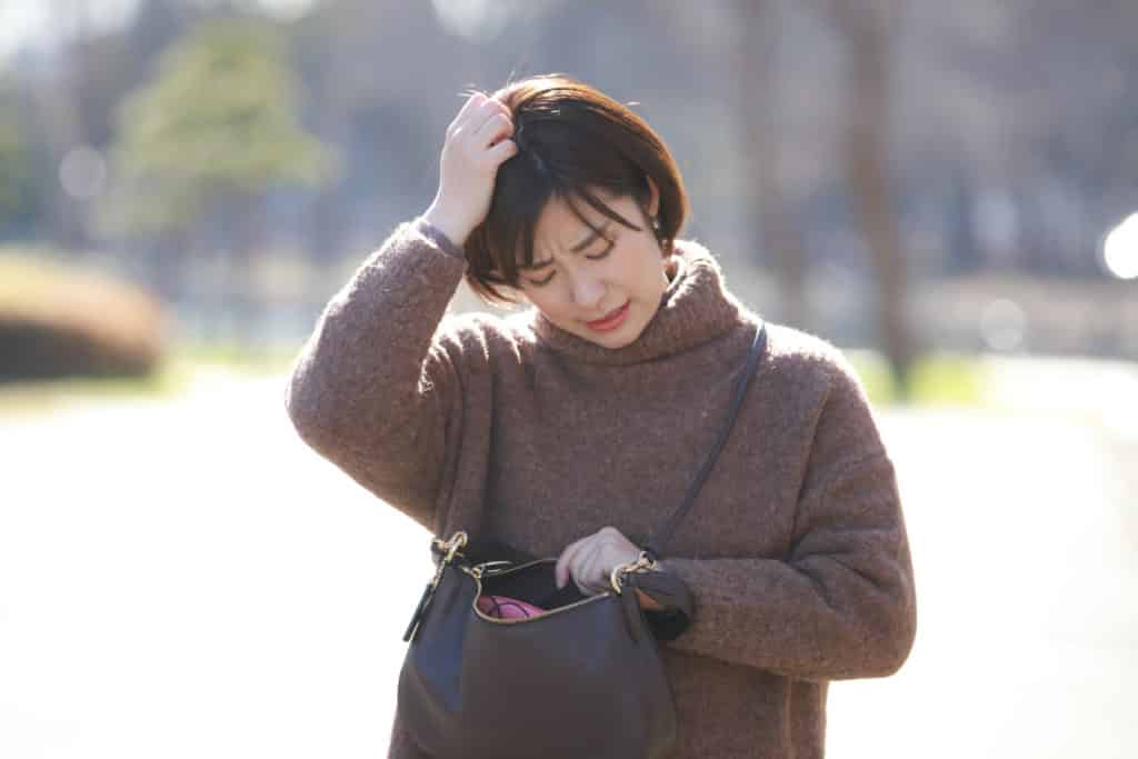Woman noticing items missing from her handbag