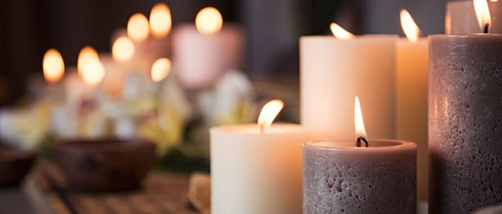 Lit candles in soft tones arranged for a calming ambiance, ideal for wellness or spa settings.